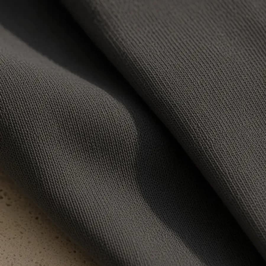 Close view of charcoal cotton knit, folded over itself.